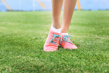 Woman wearing pink sneakers and standing on a grass