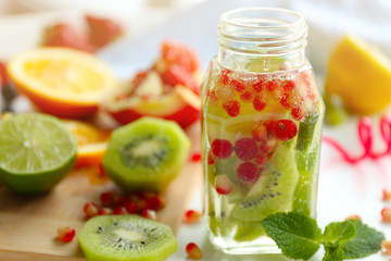 Refreshing water with fruits on table