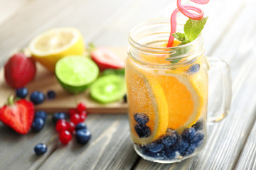 Refreshing water with fruits on table