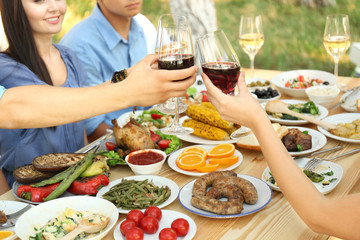 Obraz na płótnie Canvas Friends cheering with glasses of wine on picnic