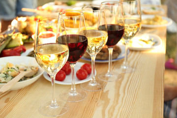 Glasses of different wine on wooden table