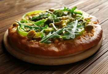 Tasty vegetarian pizza on wooden background