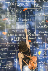 Mujer joven el el Muro de "Je t'aime" en París