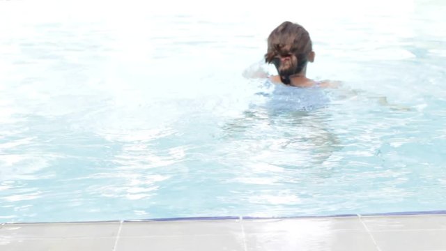 Child swims in the pool