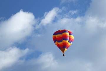 Fototapeta na wymiar Multi colorful hot air balloon floating in the clouds