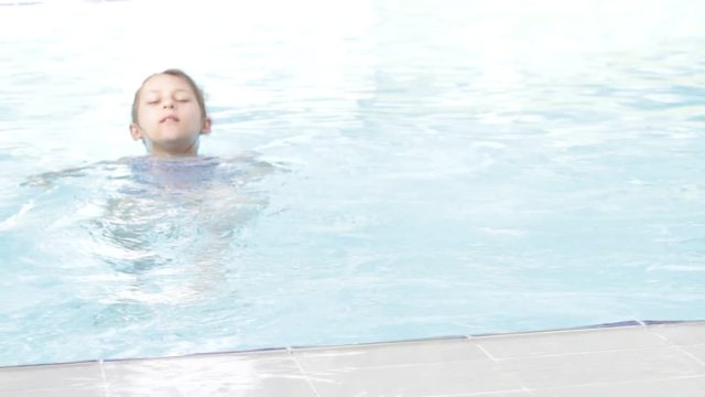 Child swims in the pool