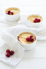 Homemade raspberry crumble on white wooden background