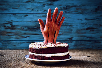cake topped with a bloody hand for halloween