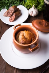 Sausage Yorkshire pudding in the baking pot on wooden background close up. English Toad in the Hole, a traditional British dish.