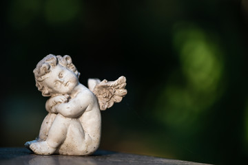 Engelchen sitzt auf einem Grab, für Trauerkarte