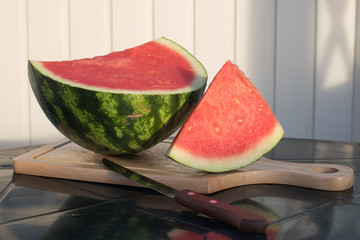 seedless watermelon and slice of watermelon lying on a cutting Board near the knife