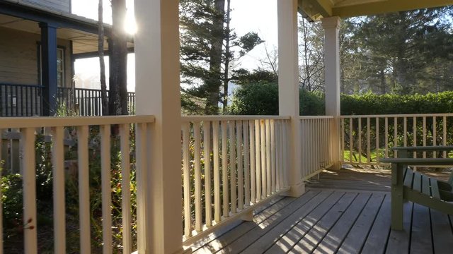 Sunlight shines through railings on beach house porch