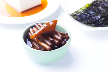 Close up of Korean Summer Pickles Garlic Scapes in a bowl on whi