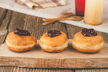 Homemade donuts with jam on wooden table