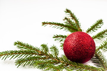Christmas tree branch with glass ball isolated on white background