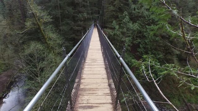 POV shot walking across suspension bridge