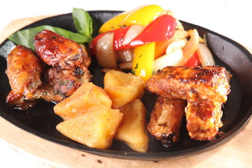 metal pan with chicken wings and vegetables
