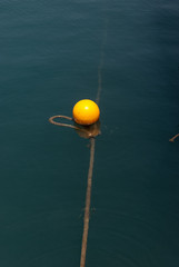 Yellow buoy on calm blue sea water surface