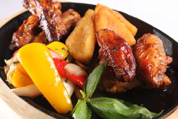 metal pan with chicken wings and vegetables