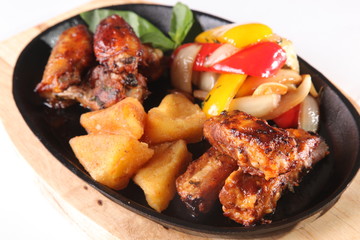 metal pan with chicken wings and vegetables