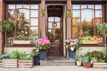 Blumenladen oder Caféeingang mit Blumen geschmückt. Rustikales Stilkonzept. Schöne Designelemente