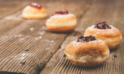 Obraz na płótnie Canvas Homemade donuts with jam on wooden table