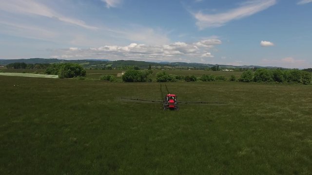 Aerial shot of tractor spraying grass seed farm