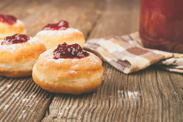 Homemade donuts with jam on wooden table