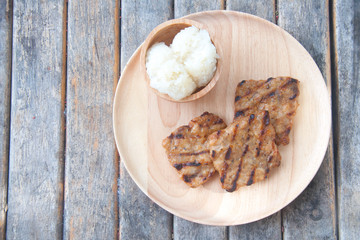 Grill pork with sticky rice on wood plate