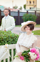 Beautiful young woman in dress and hat portrait in retro style. The young gentleman and lady. Vogue...
