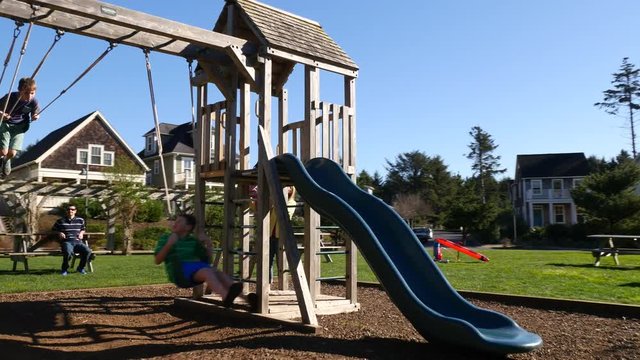 Kids swinging and playing at park