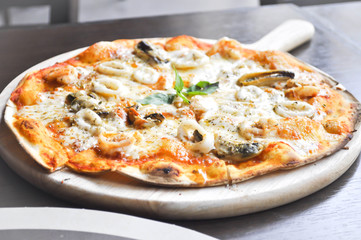 seafood pizza in the wooden  tray or thin pizza
