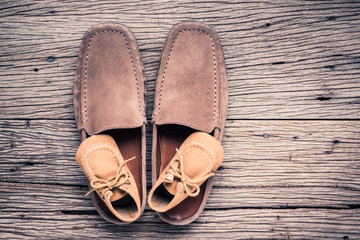 still life photography : father and child shoes on old wood in vintage color tone, go ahead together concept