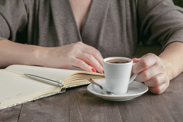 Cup of coffee on the desk and woman working on his plane project