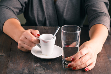 Woman drinking water after espresso coffee