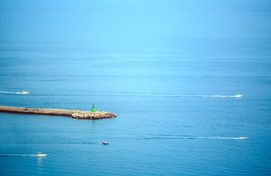 Minimalistic seascape of jetty with small lighthouse