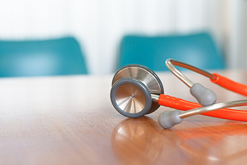 Medical, Stethoscope orange placed on a wooden background blur.