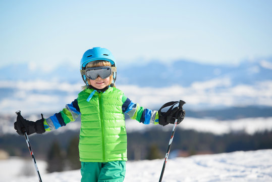 Smiling skier boy has fun in the mountains on a sunny day