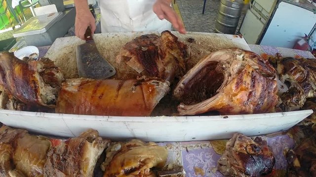 Cutting Crispy Roast Pig / Skilled butcher cutting succulent roast pig with meat cleaver at the carvery station. HD1080p. GoPro HERO3+Black Edition