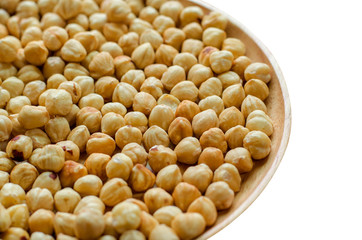 Hazelnuts in spoon and plate wooden on white background