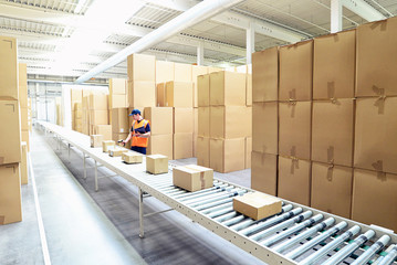 Logistik im Onlinehandel - Arbeiter im Warenlager verschickt Pakete // logistics for online trading...