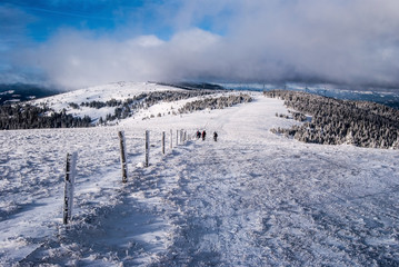 Fototapeta na wymiar winter in Fischbacher Alpen mountain range bellowe Stuhleck peak in Styria with blue sky and clouds