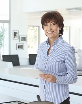 Casual senior businesswoman at home with tablet