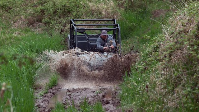 Man drives atv through mud, slow motion
