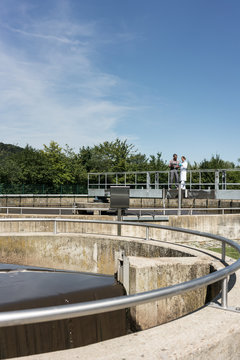 Wastewater treatment plant - man and woman standing at sedimentation tank