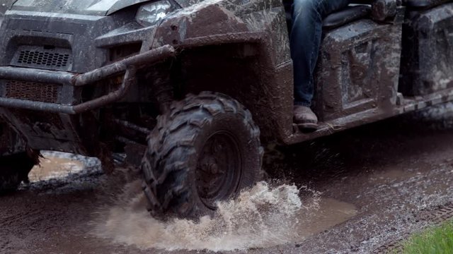 Closeup of atv going through mud in slow motion