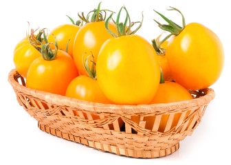 yellow tomatoes in a wicker basket isolated on white background