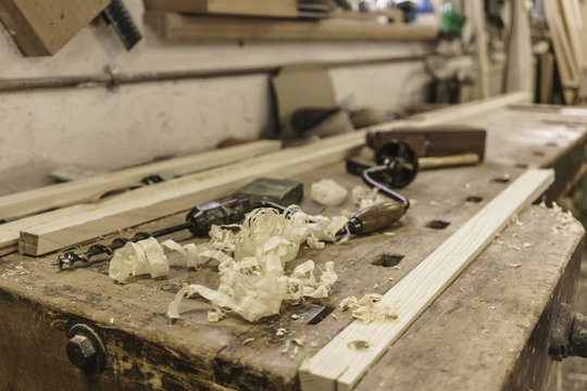 Mechanic drill, plane and wood shavings lying on workbench at carpenter workshop