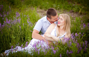 Young man and woman couple in love lying in the grass on the nature or flowers