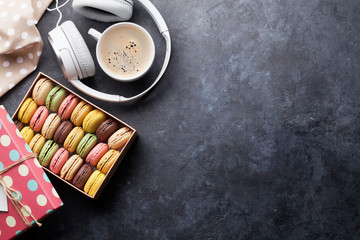 Colorful macaroons in a gift box and headphones